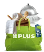 Groene PLUS-tas gevuld met wellnessproducten zoals een houten emmer, badborstel, witte handdoek en houten spatel.