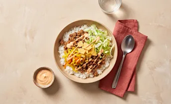 Pittige rijstbowl met gehakt, atjar en tortillachips