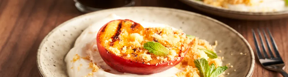 Gegrilde perziken met yoghurt en koekcrumble