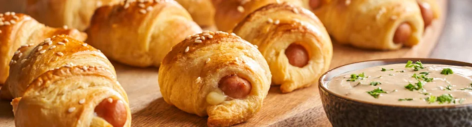 Knakworstjes in croissantdeeg met kruidige yoghurtdip