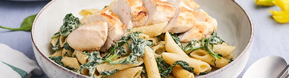Kipfilet in pesto-roomsaus met spinazie en penne pasta