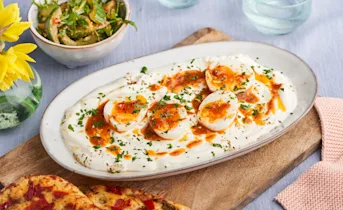 Zachte eitjes in pittige yoghurt met focaccia en komkommersalade