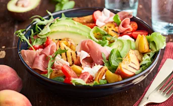 Maaltijdsalade met gegrilde perziken en gedroogde ham