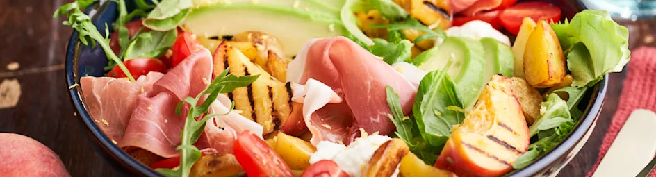 Maaltijdsalade met gegrilde perziken en gedroogde ham