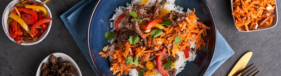Rijst met kruidige runderreepjes en wortelsalade