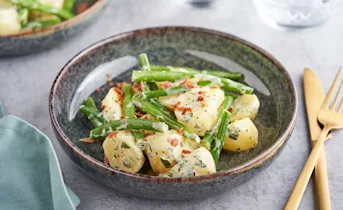 Lauwwarme aardappel sperziebonen salade met spekjes en yoghurt munt dressing