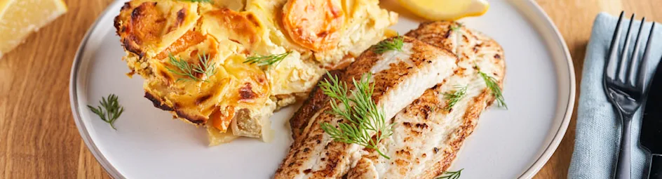 Gebakken scholfilet met aardappelschotel van prei en wortel in mosterdsaus