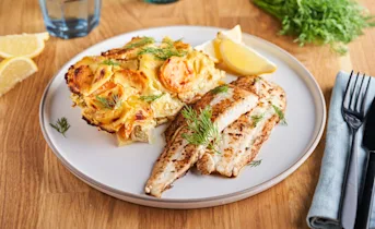 Gebakken scholfilet met aardappelschotel van prei en wortel in mosterdsaus