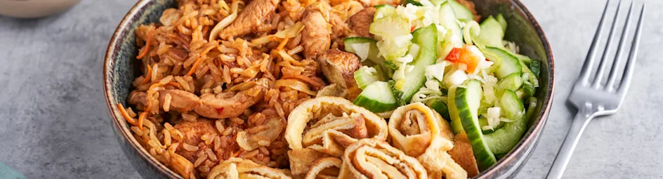 Gebakken rijst met kip ketjap, spitskool, wortel, omeletreepjes en atjar van komkommer