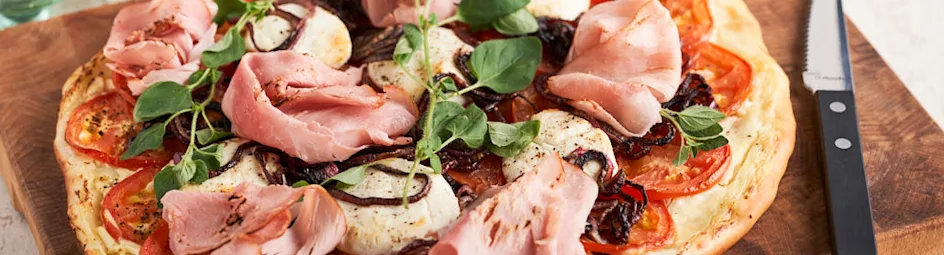 Hartige plaattaart met creme fraiche, abdijham, geitenkaas en trostomaten, rode ui en oregano