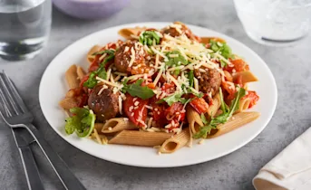 Pasta vegaballetjes met rucola in pittige tomatensaus