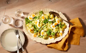 Aardappelsalade met zachtgekookte eieren en veldsla