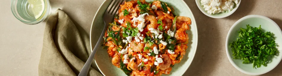 Orzo met garnalen in feta in een tomatensaus