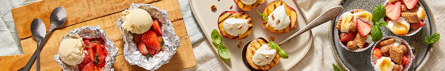 BBQ-toetjes, waaronder gegrilde witte nectarines, mini s'mores met aardbei en chocolade en aardbeien-gemberpakketjes met prosecco.