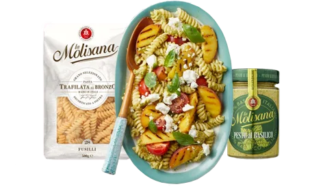 Koude pastasalade met pesto, gegrilde perzik, cocktailtomaten en feta