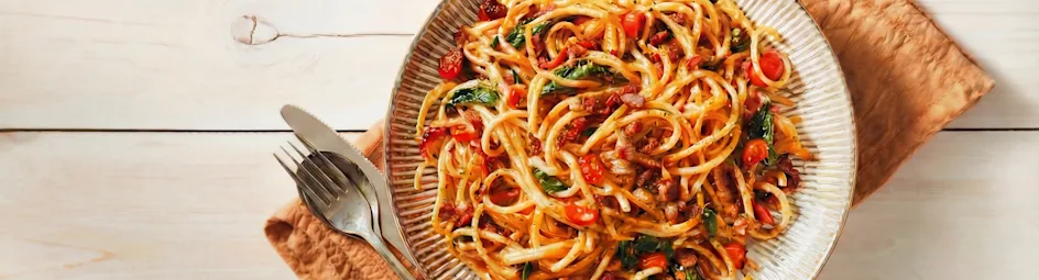 Vegetarische pasta carbonara met plantaardige spekjes en spinazie