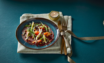 Carpaccio met pestosaus, rucola en zongedroogde tomaatjes