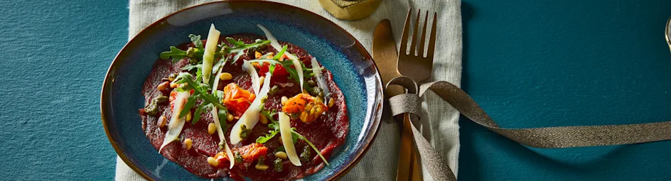 Carpaccio met pestosaus, rucola en zongedroogde tomaatjes