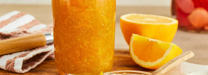 Een glazen pot met oranje marmelade