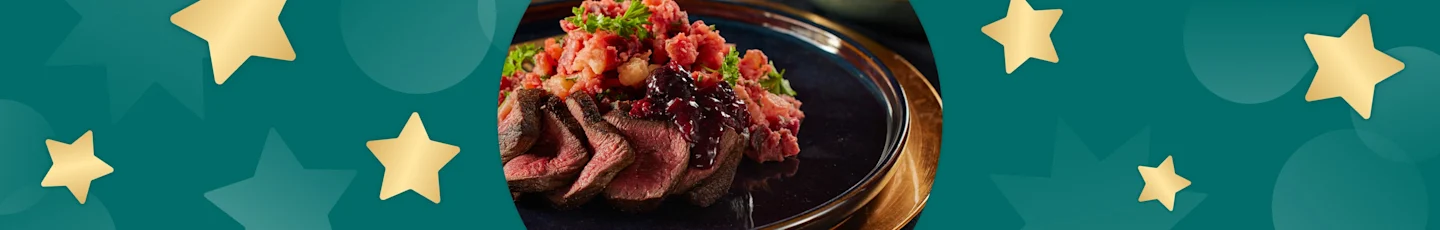 Vleesgerecht voor Kerst van hertenbiefstuk met bosvruchtensaus en biet-peterseliestamppot.