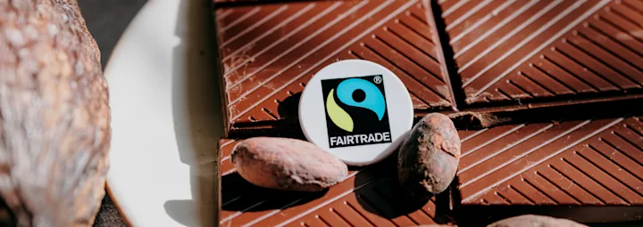 Chocolade met enkele cacaobonen en het Fairtrade-logo.