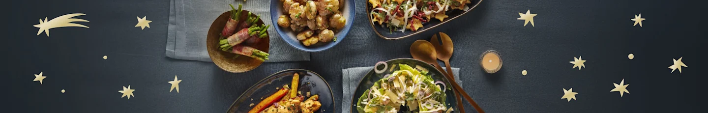 Kerst bijgerechten op een gedekte tafel.