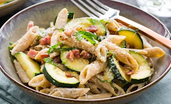 Magere penne carbonara met yoghurt, spek en courgette