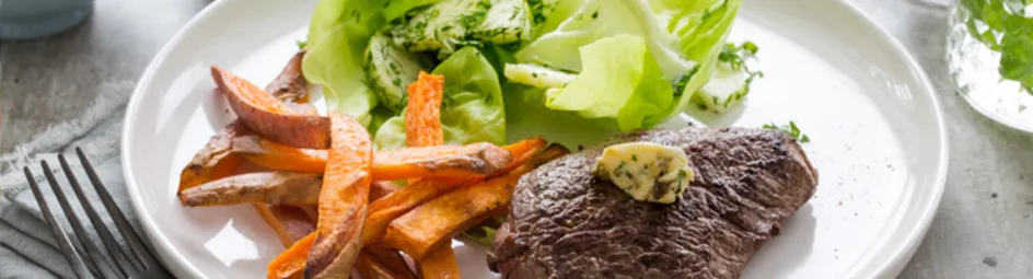 Steak frites met beurre café de Paris en zoete aardappelfriet en salade