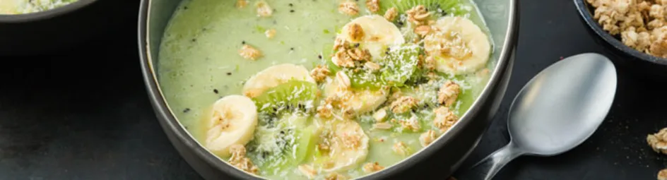 Groene smoothiebowl met kiwi, banaan, kokos en muesli