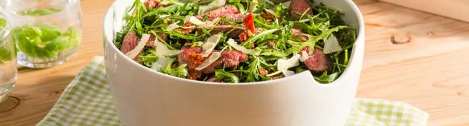 Italiaanse salade met gegrilde biefstuk, balsamico-dressing, rucola en zongedroogde tomaatjes