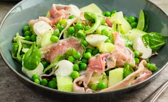 Frisse salade met meloen, mozzarella en gedroogde ham