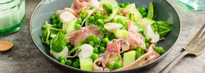 Frisse salade met meloen, mozzarella en gedroogde ham