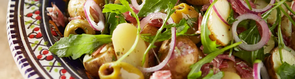 Lauwwarme aardappelsalade met salami en olijven