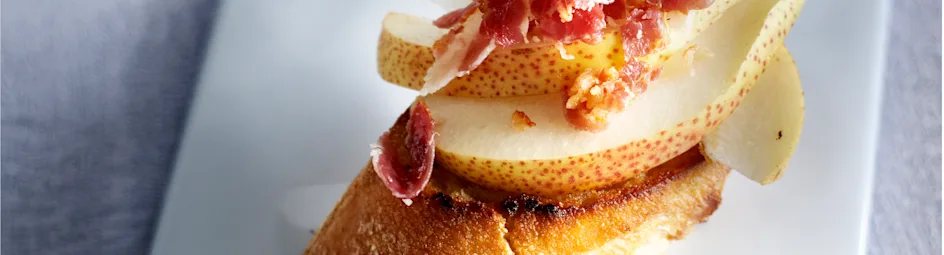 Crostini met olijfolie, peer en pancettakruimels