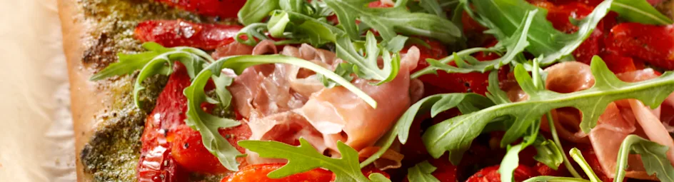 Pizza met rauwe ham, paprika en rucola