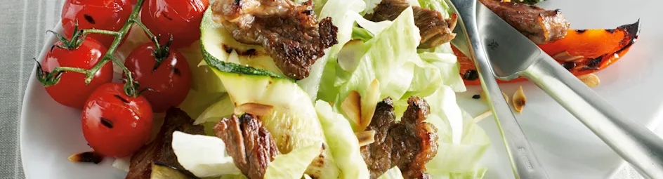 Maaltijdsalade met honing-komijndressing en geroosterde amandelen