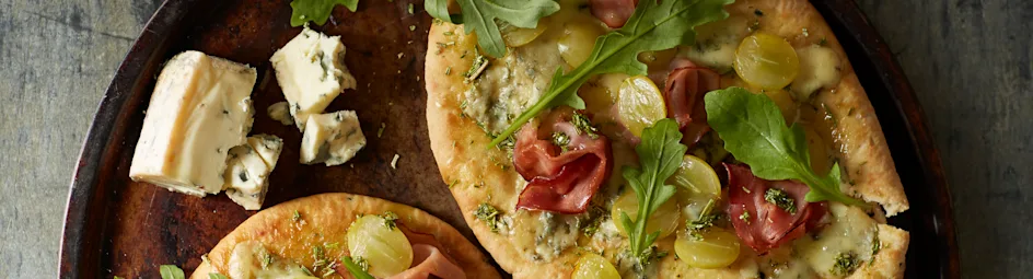 Platbrood met blauwe kaas, rauwe ham en druiven