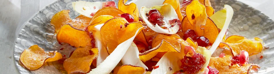 Witlofsalade met peperige zoete-aardappelchips en granaatappeldressing