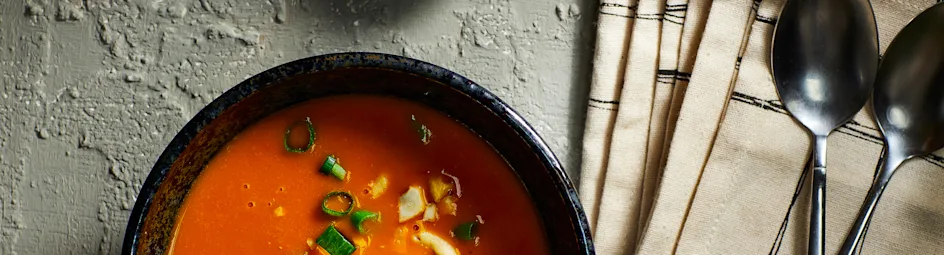 Lichte pompoensoep met tomaat, sambal-olie en cashewnoten