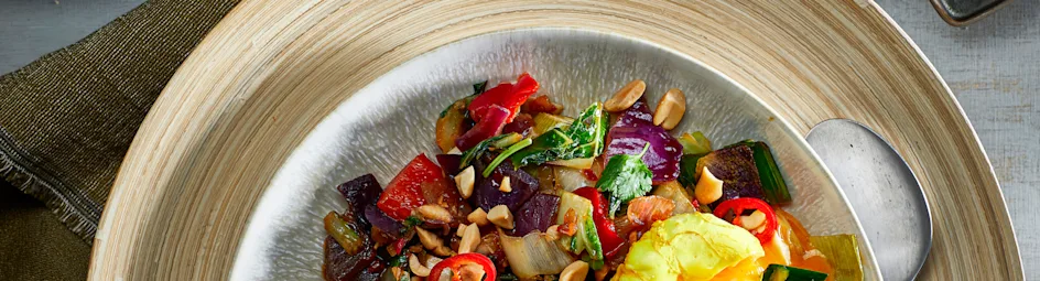 Groenteroerbak met gepocheerde koenjit-eieren