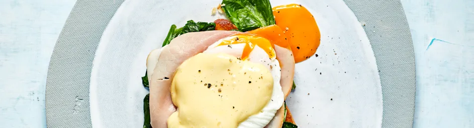 Eggs benedict met ham, spinazie en hollandaisesaus