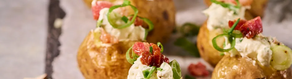 Gepofte aardappeltjes met creme fraiche, bosui en spekjes