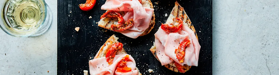 Bruschette met bonen, mortadella en tomaatjes