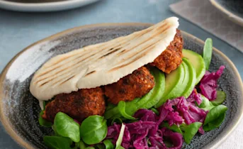 Vegan pita falafel met rode kool, avocado en soya yoghurtsaus