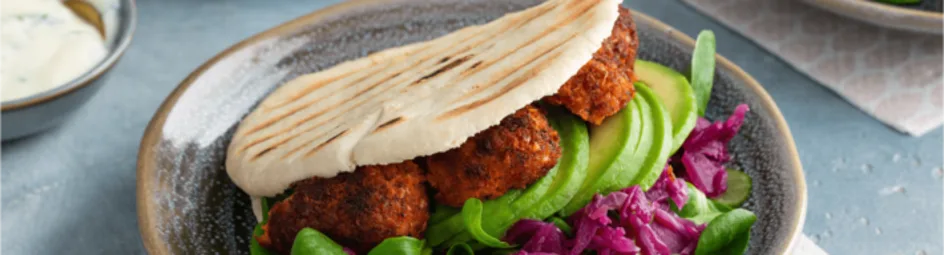 Vegan pita falafel met rode kool, avocado en soya yoghurtsaus