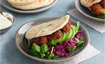 Vegan pita falafel met rode kool, avocado en soya yoghurtsaus