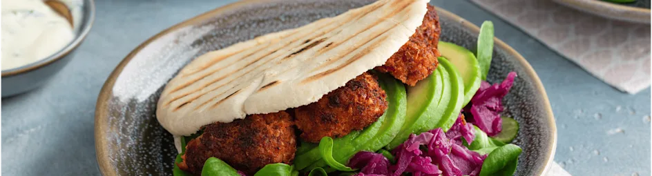 Vegan pita falafel met rode kool, avocado en soya yoghurtsaus