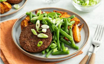 Vegetarische burger met Mexicaans gekruide aardappelen en sperziebonen