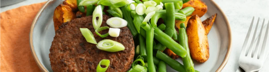 Vegetarische burger met Mexicaans gekruide aardappelen en sperziebonen