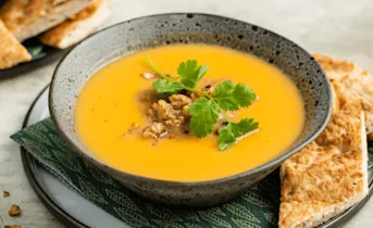 Romige zoete aardappelsoep met sinaasappel en walnoten